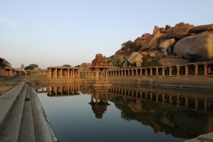 Hampi ruins with intricate stone carvings and calm water, one of the best places to visit in Karnataka in February.