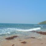 Anjuna Beach with golden sand and palm trees, among places to visit in Goa near Mapusa.