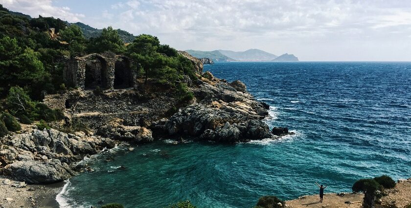 Scenic Alanya beach with rock cliffs and greenery, ideal places to visit near Antalya.