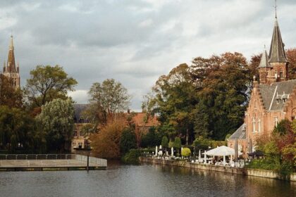 Historic church by the river in Bruges, one of the best places to visit near Brussels.