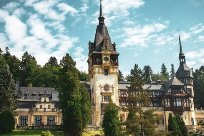 Peleș Castle in Sinaia surrounded by trees and mountains, one of the best places to visit near Bucharest