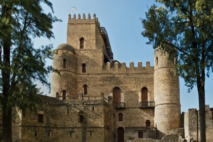 Fasiledes Castle in Ethiopia with ancient stone architecture and trees around it places to visit near Kenya.