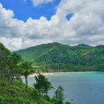 Aerial view of Koh Phangan with turquoise waters and lush hills, places to visit near Koh Samui.
