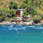 Yelapa beach cove with boats and palm trees, one of the best places to visit near Puerto Vallarta.