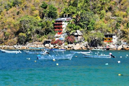 Yelapa beach cove with boats and palm trees, one of the best places to visit near Puerto Vallarta.