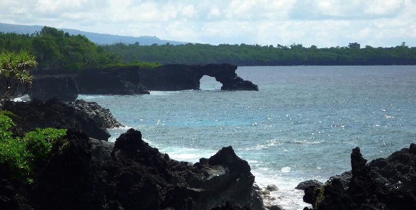 Lush green mountains meet crystal-clear waters along the serene coastline of the Samoa Islands.