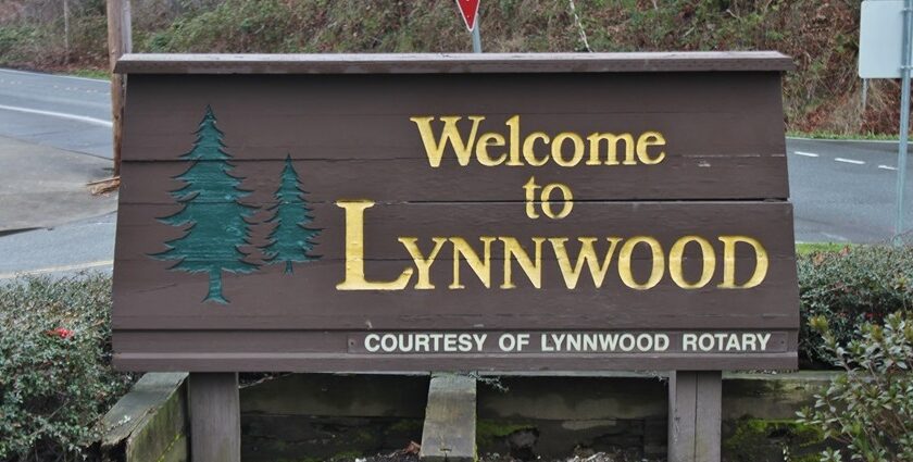 A welcome sign in northern Lynnwood, Washington, surrounded by ferns and mosses.