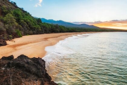Relaxing at the Kaanapali Beach with sandy shores and distant mountains, one of the best things to do in Maui.