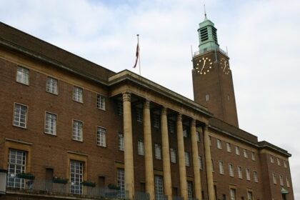 A large building with tall columns and a clock tower, viewed from a street, one of the best things to do in Norwich CT.