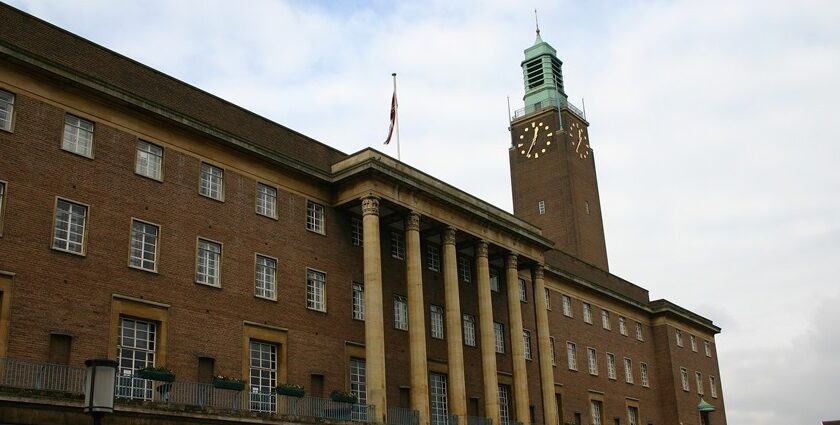 A large building with tall columns and a clock tower, viewed from a street, one of the best things to do in Norwich CT.