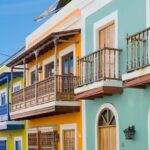 Elegant pink waterfront building with arched windows, palm trees, one of the best things to see in Old San Juan.