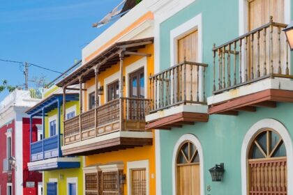 Elegant pink waterfront building with arched windows, palm trees, one of the best things to see in Old San Juan.