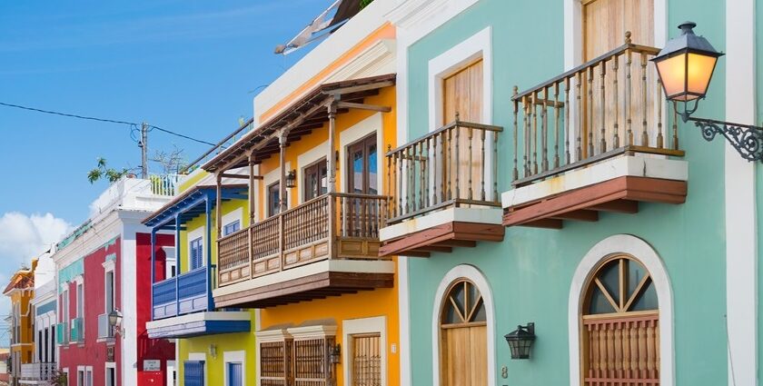 Elegant pink waterfront building with arched windows, palm trees, one of the best things to see in Old San Juan.