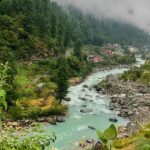 Serene river flowing through lush greenery in Kasauli, among places to visit near Chandigarh in winters.