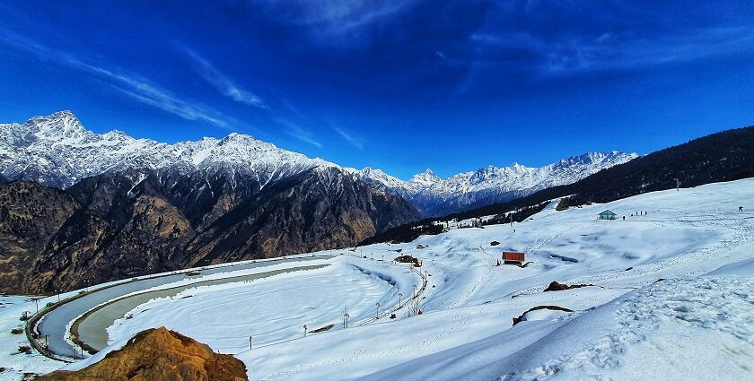 Auli snow covered mountains in winter among cold places to visit near Delhi.