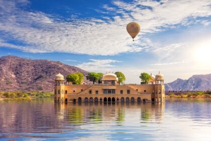 The scenic view of the Jal Mahal in Jaipur, surrounded by calm waters and green hills, during long weekends in 2025 in India.
