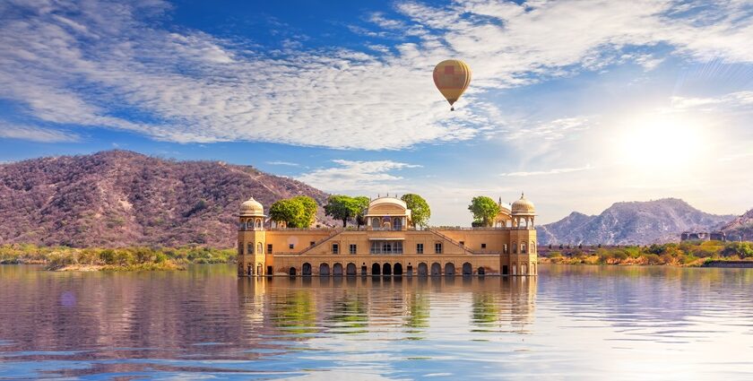 The scenic view of the Jal Mahal in Jaipur, surrounded by calm waters and green hills, during long weekends in 2025 in India.
