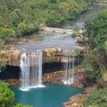 Khrangsuri Waterfall flowing into a blue pool with greenery places to visit near Barapani.