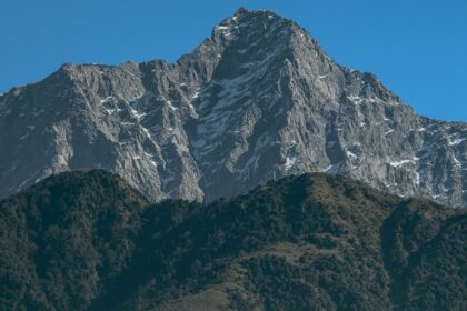 Snow-dusted mountains in Mcleodganj under clear sky are among places to visit near Dalhousie in December.