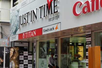 An image of FC Road, with various shops and visitors and two-wheelers parked outside.