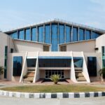 Modern architectural perspective of the Gachibowli Indoor Stadium under a blue atmosphere.