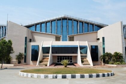 Modern architectural perspective of the Gachibowli Indoor Stadium under a blue atmosphere.
