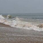 Marina Beach shoreline with waves and walkers, one of the top places to visit near Greams Road Chennai.