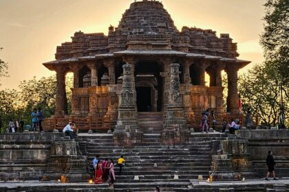 Ancient stone temple with intricate carvings gazing out to a stepped water tank beneath the sky