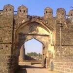 An image shows an empty pathway through the entrance of the Gulbarga Fort in Karnataka.