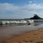 Malpe Beach with palm trees and waves, one of the top places to visit near Hebri.