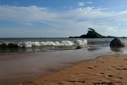 Malpe Beach with palm trees and waves, one of the top places to visit near Hebri.
