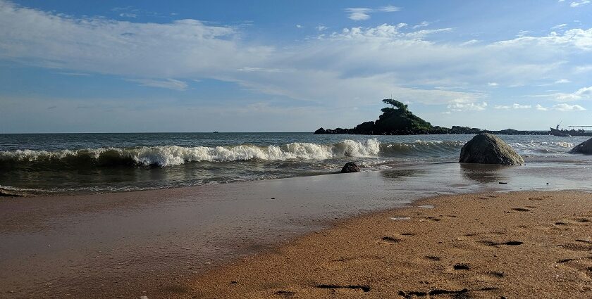 Malpe Beach with palm trees and waves, one of the top places to visit near Hebri.