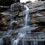 Patalpani Waterfall cascades over a rocky cliff, one of the scenic places to visit near Indore in July.