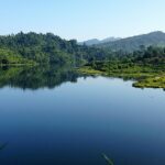 A scenic view of the Shilloi Lake surrounded by lush greenery, one of the stunning places to visit near Kohima.