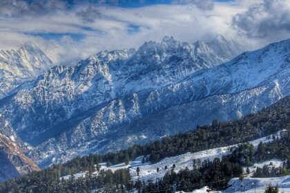 Stunning view of snow-covered mountains with clear skies, refliecting what is Auli famous for.