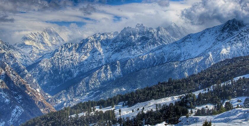 Stunning view of snow-covered mountains with clear skies, refliecting what is Auli famous for.