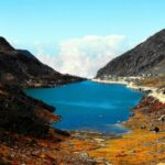 Black and brown mountain with lake in Sikkim showing what is Sikkim famous for.