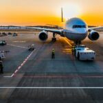 An airplane taking off at sunset with scenic skies at one of the airports in Bali.