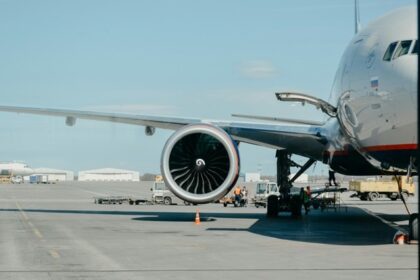 Aeroplanes parked at airport gates with staff and ground vehicles nearby, one of the Airports in North East.