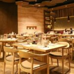 Interior of a restaurant with tables, chairs, and dim lighting, one of the best restaurants in Guwahati for dinner.