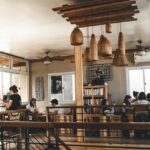 Cosy café interior with wooden tables, framed photos, surfboard décor and warm lights in one of the cafes in Gangtok.