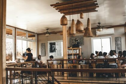 Cosy café interior with wooden tables, framed photos, surfboard décor and warm lights in one of the cafes in Gangtok.