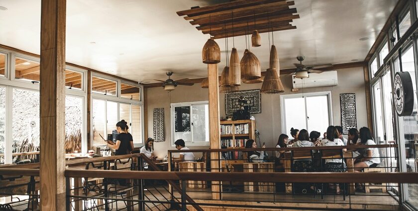 Cosy café interior with wooden tables, framed photos, surfboard décor and warm lights in one of the cafes in Gangtok.