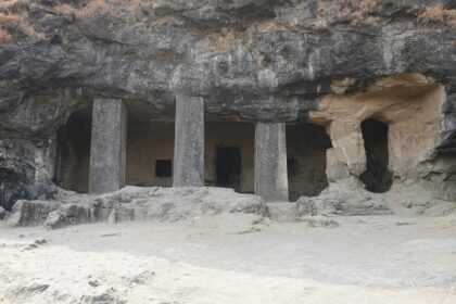 Four stone pillars and rugged rock formations at Kavala Caves, one of the popular caves in Karnataka.