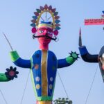 Tall Ravan effigy standing decorated during the day for the Dussehra celebration in India.
