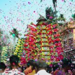A group celebrating with confetti in a vibrant street event during festivals in Tamil Nadu.