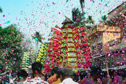 A group celebrating with confetti in a vibrant street event during festivals in Tamil Nadu.