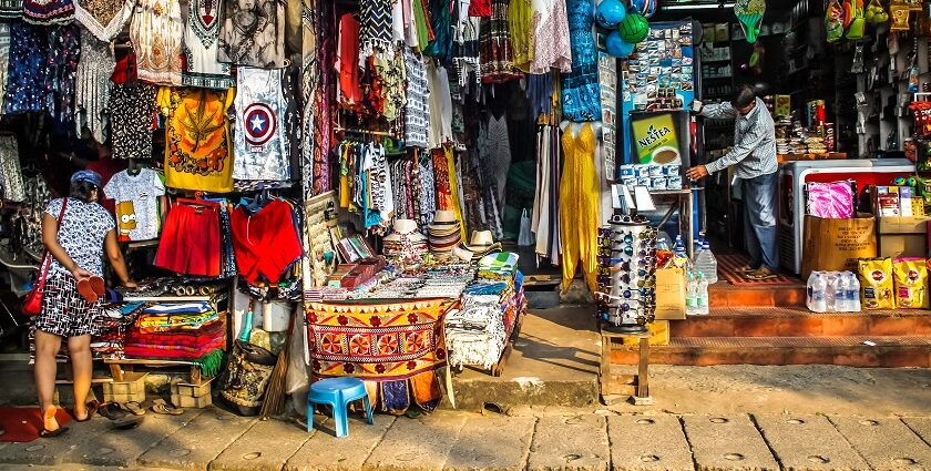 A lively outdoor market with vendor stalls and people walking around a city square.