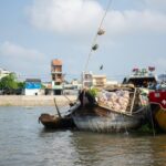 A bustling floating market with many narrow boats selling fresh fruits and vegetables.