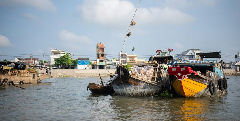 A bustling floating market with many narrow boats selling fresh fruits and vegetables.